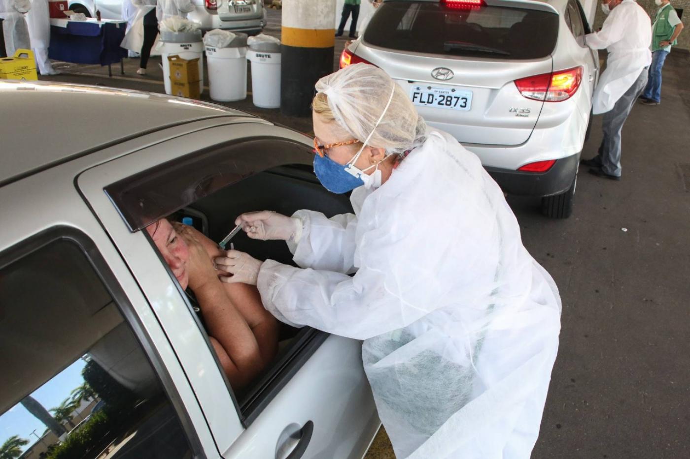 profissional da saúde vacina pessoa em carro #paratodosverem 