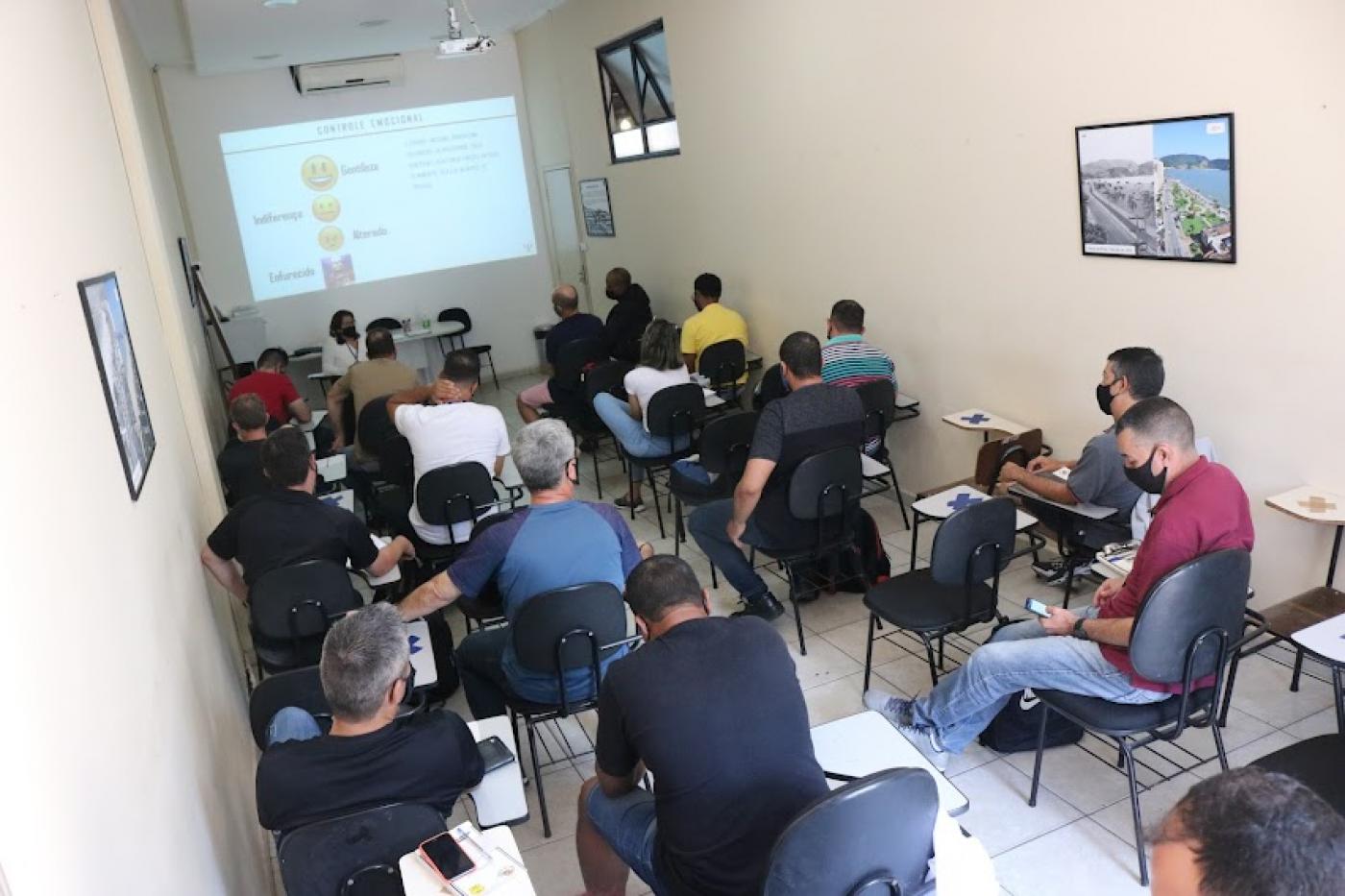Sala do curso com agentes sentados olhando pro telão #paratodosverem