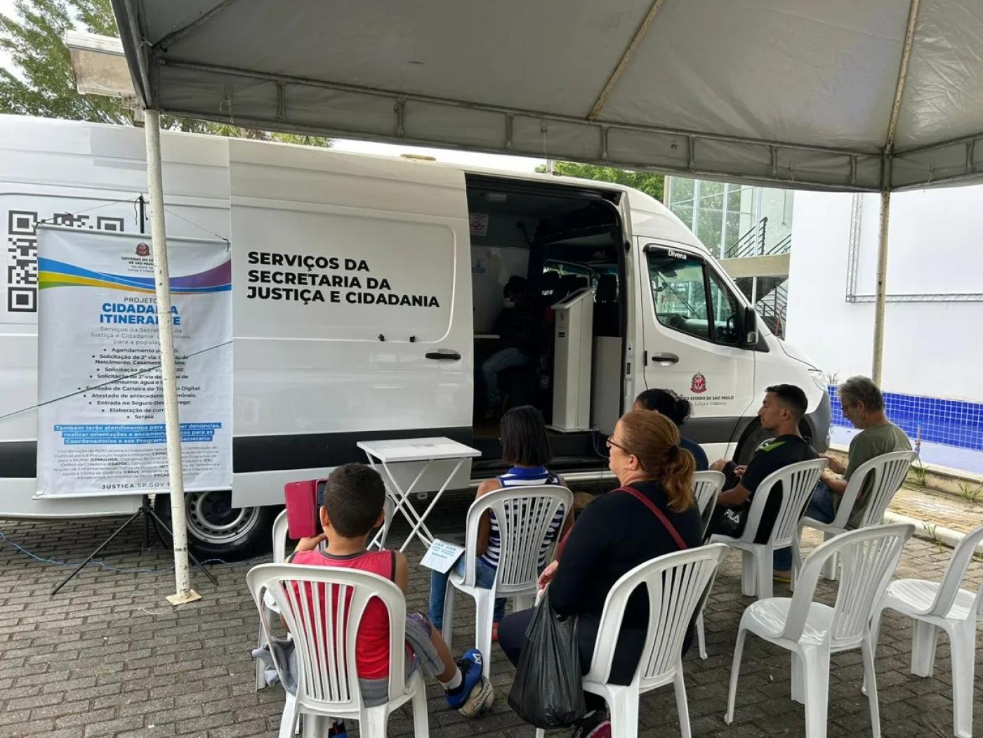 van de serviços com pessoas sentadas à frente. #paratodosverem 