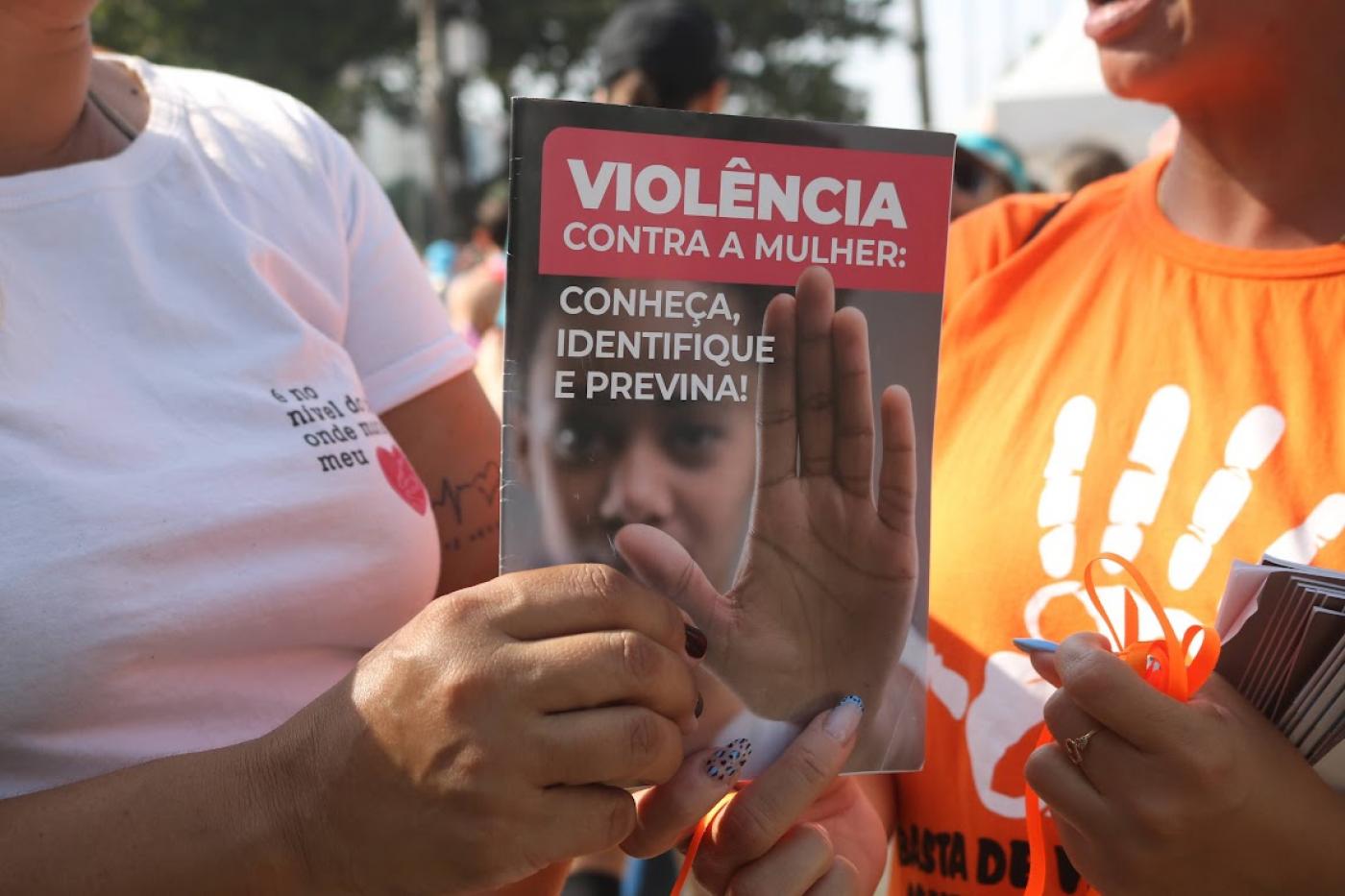 pessoa segura panfleto com mensagem contra a violência #paratodosverem 