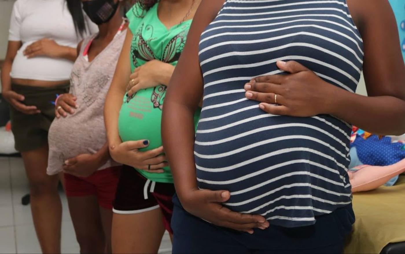 quatro gestantes enfileiradas lado a lado O foco é nas barrigas. Seus rostos não aparecem 