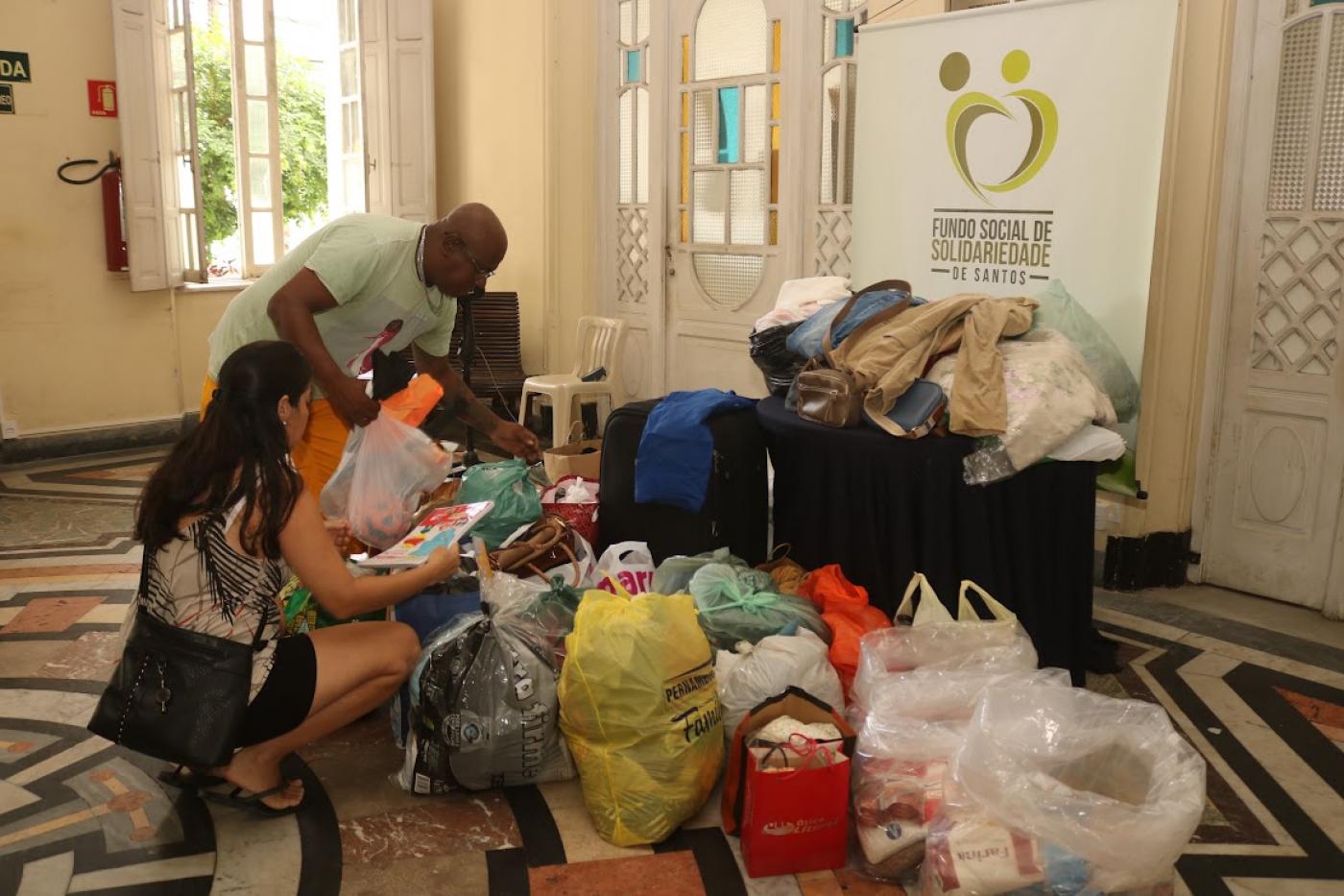 pessoas mexendo em doações #paratodosverem