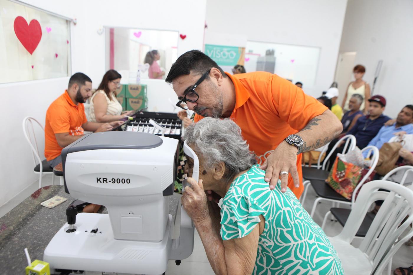 mulher coloca rosto em máquina de exame de vista. #paratodosverem