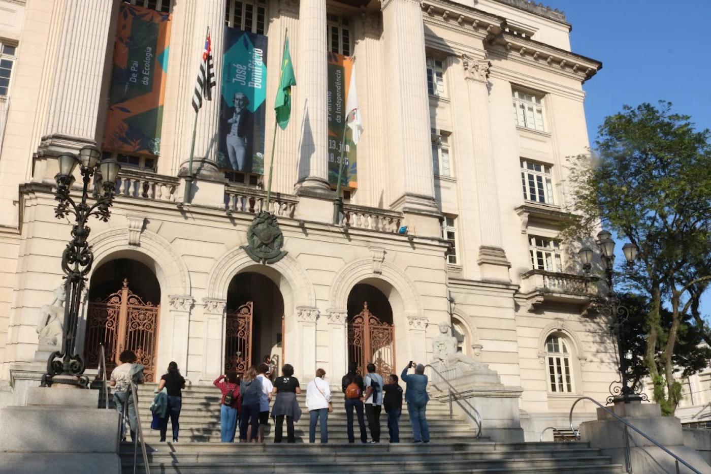 fachada do paço municipal com visitantes na escadaria se preparando para entrar no prédio. #paratodosverem