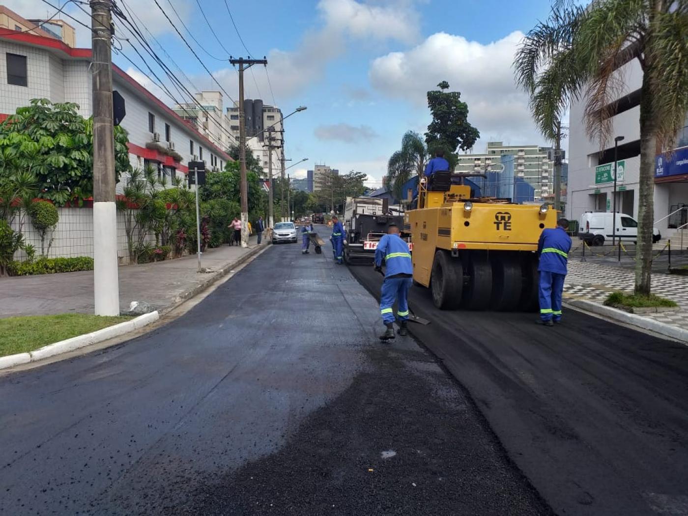 máquina e operários atuam na pavimentação #pracegover