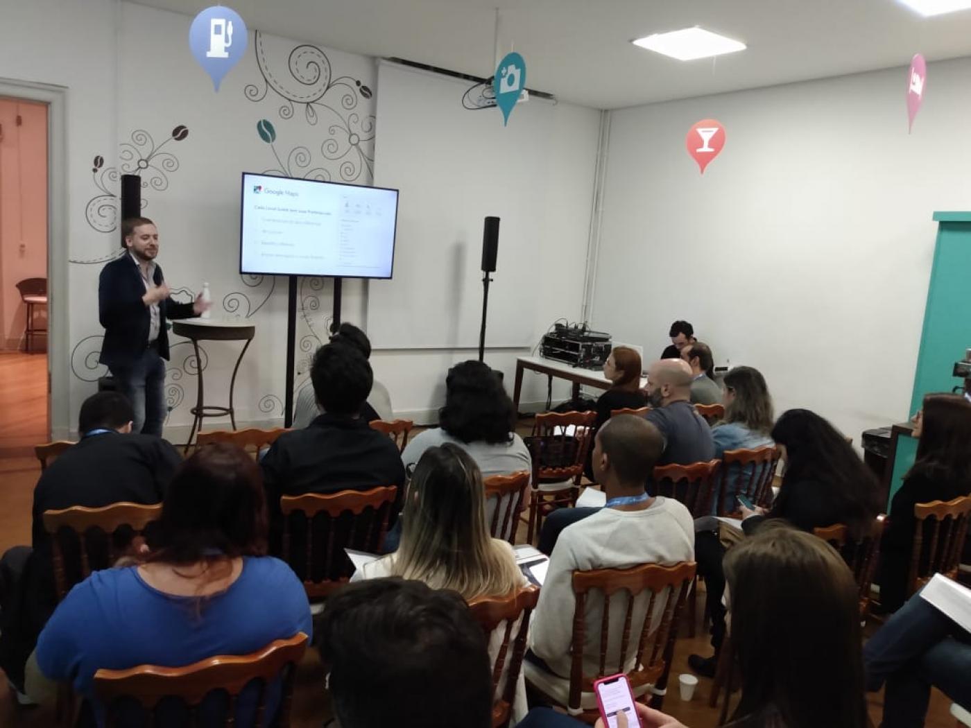 pessoas sentadas em sala vendo a apresentação da ferramenta #pracegover 