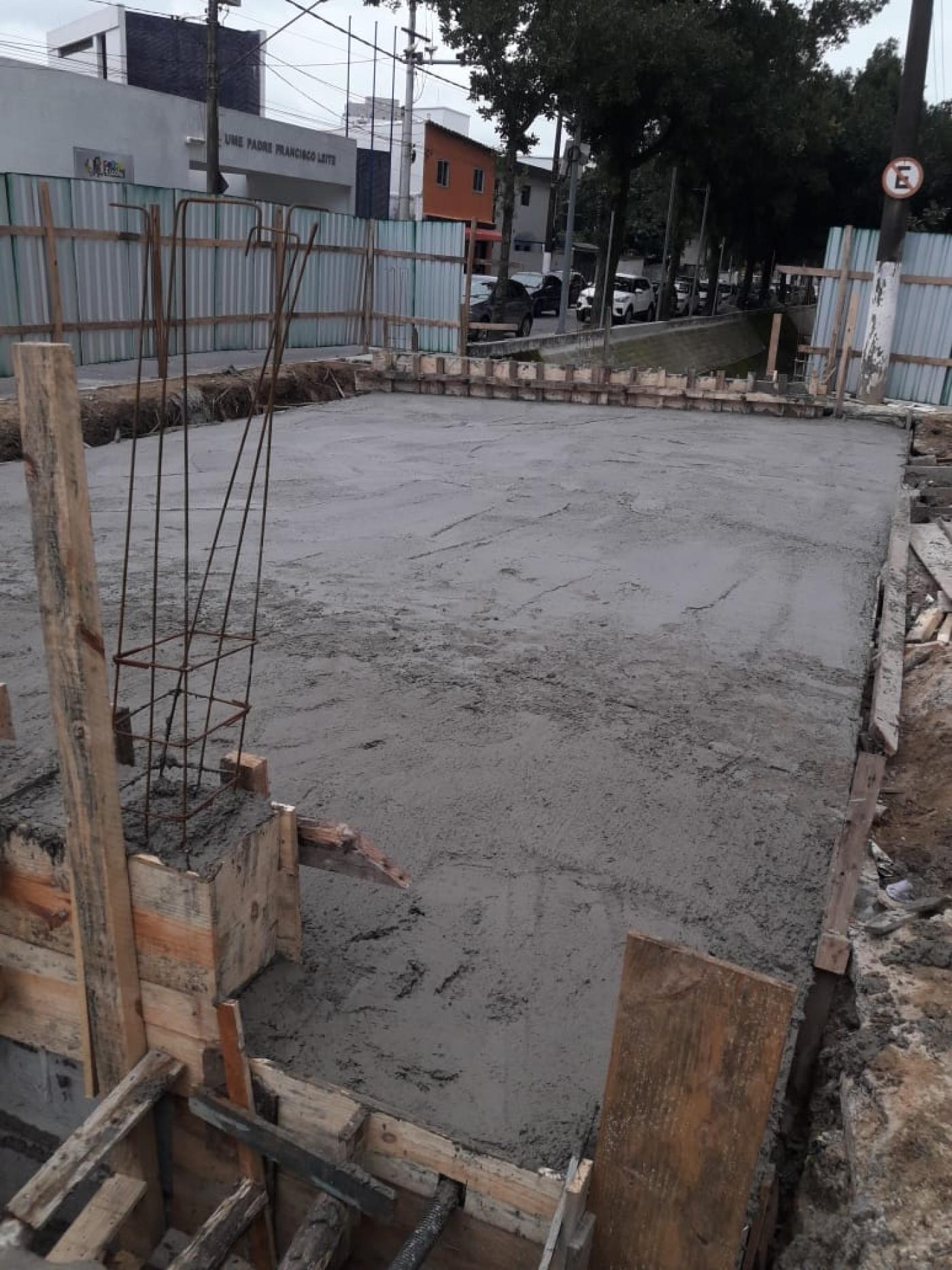 Pontilhão com área concretada. Em torno se notam as obras. #Pracegover