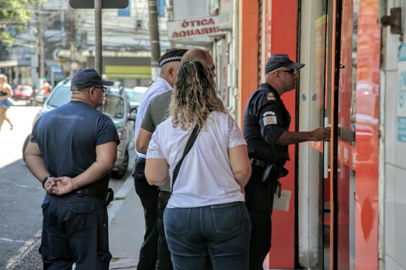 Guardas municipais estão na porta de estabelecimento que está com portas abertas. #Paratodosverem