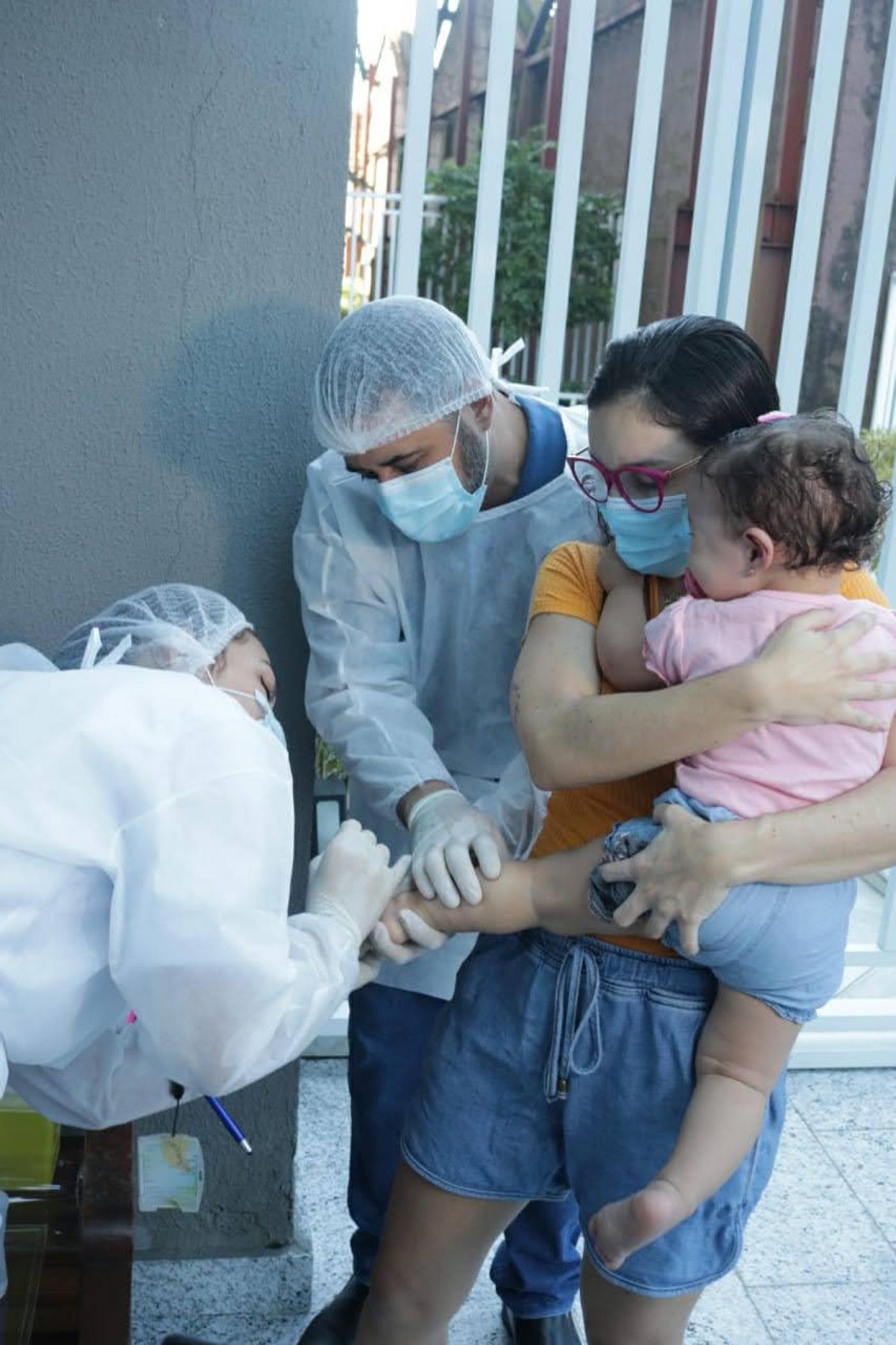 menina segurada pela mãe é testada na perna #paratodosverem 