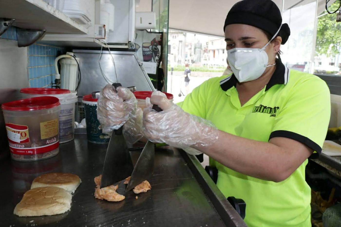 Mulher está preparando lanche em chapa. #Paratodosverem