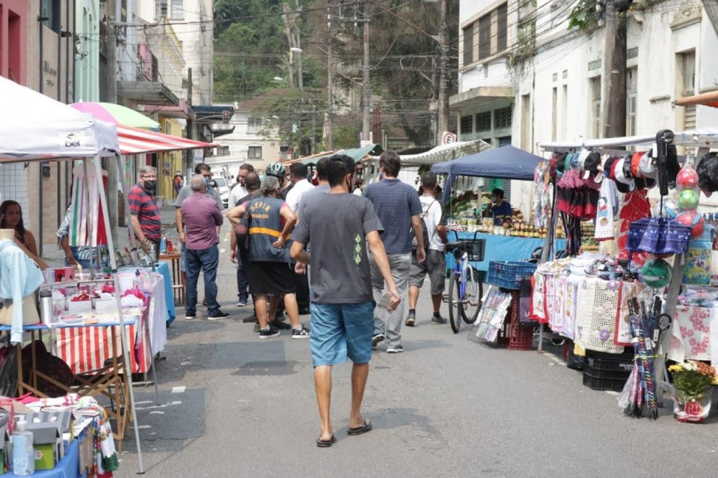 pessoas olham produtos em feira #paratodosverem 