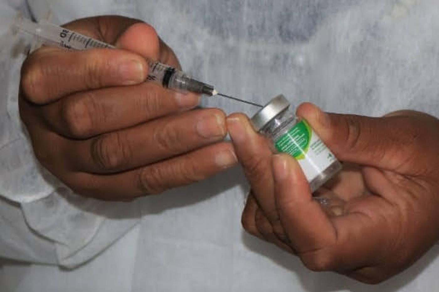 mãos preparam  seringa com vacina #paratodosverem