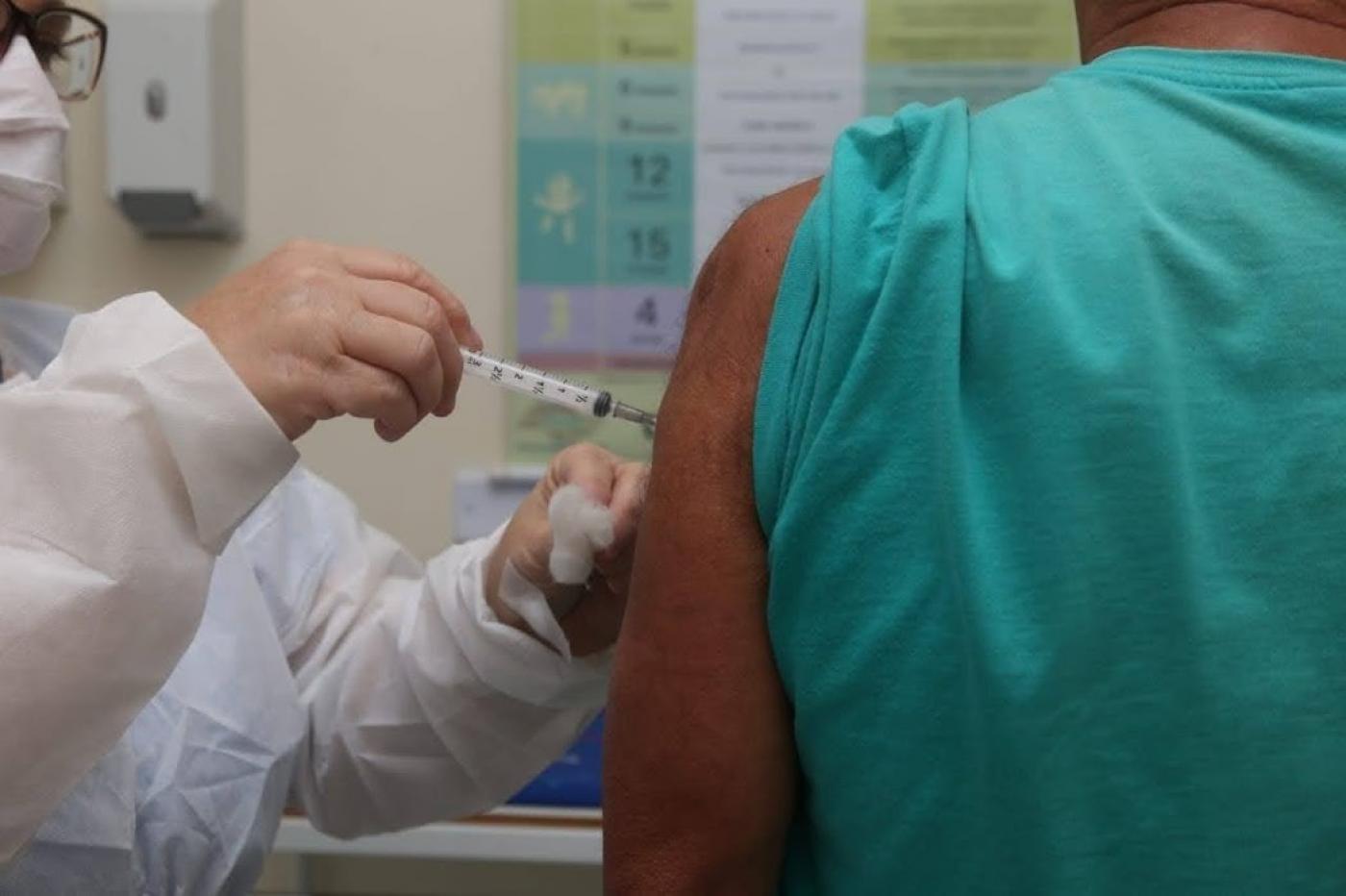 enfermeira aplica vacina em braço de homem #paratodosverem