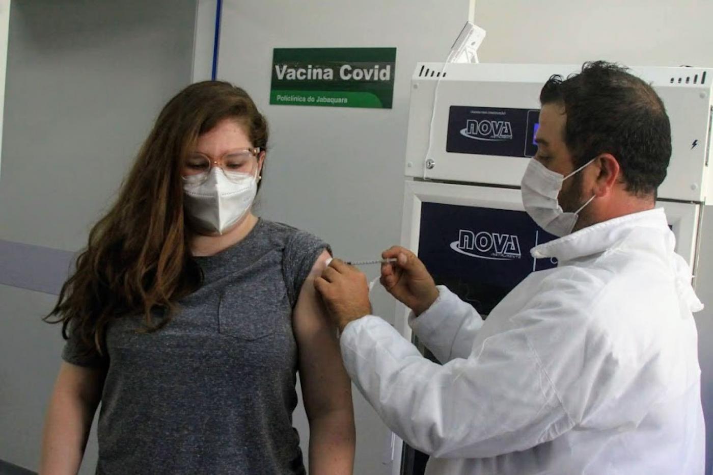 Jovem recebe aplicação da vacina de enfermeiro. #paratodosverem