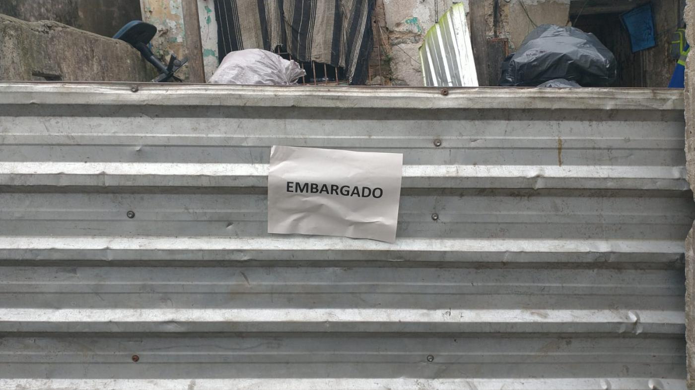 Porta metálica de ferro-velho com papel escrito embargado. #paratodosverem