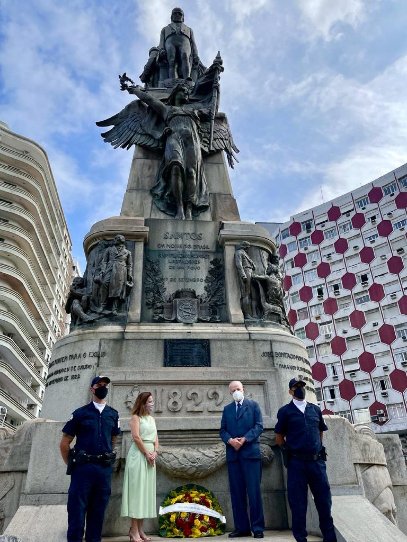 vice-prefeita e principe ao lado de coroa de flores na frente de monumento #paratodosverem