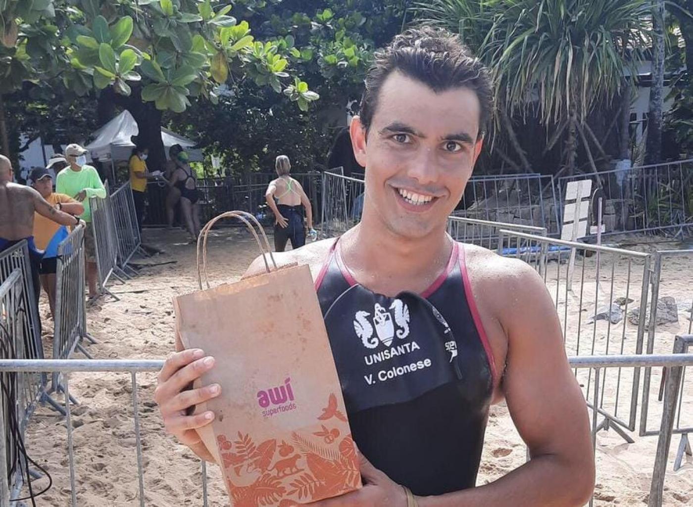 atleta exibe premios na praia #paratodosverem