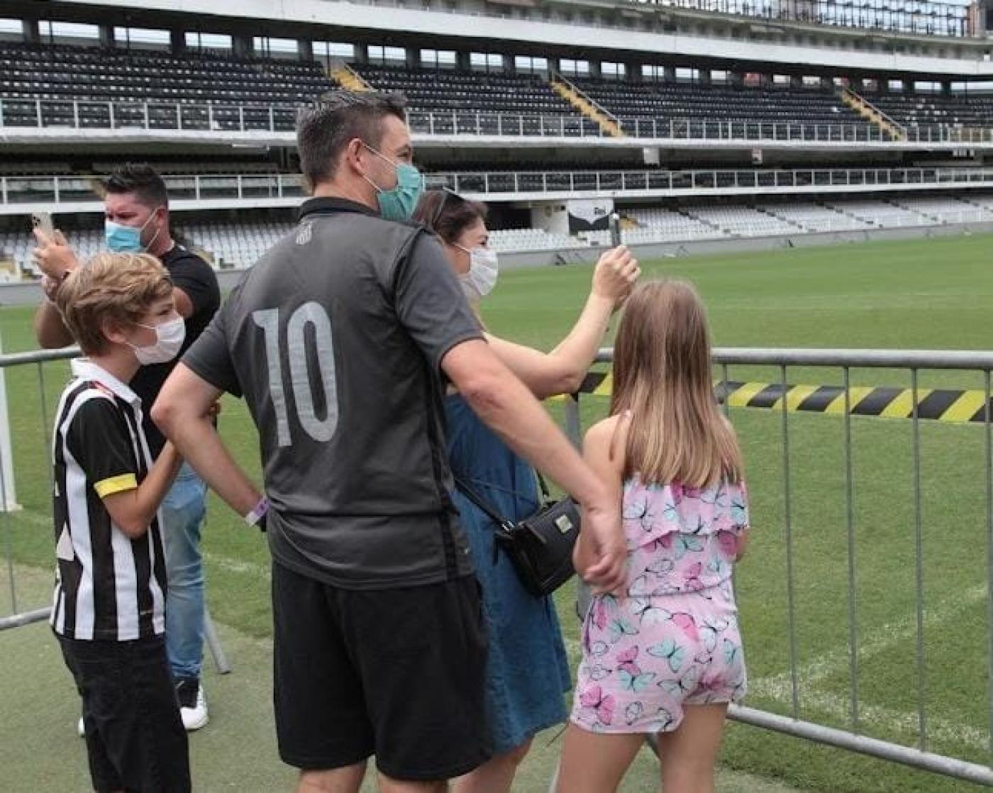 casal e filhos olham estádio do santos #paratodosverem