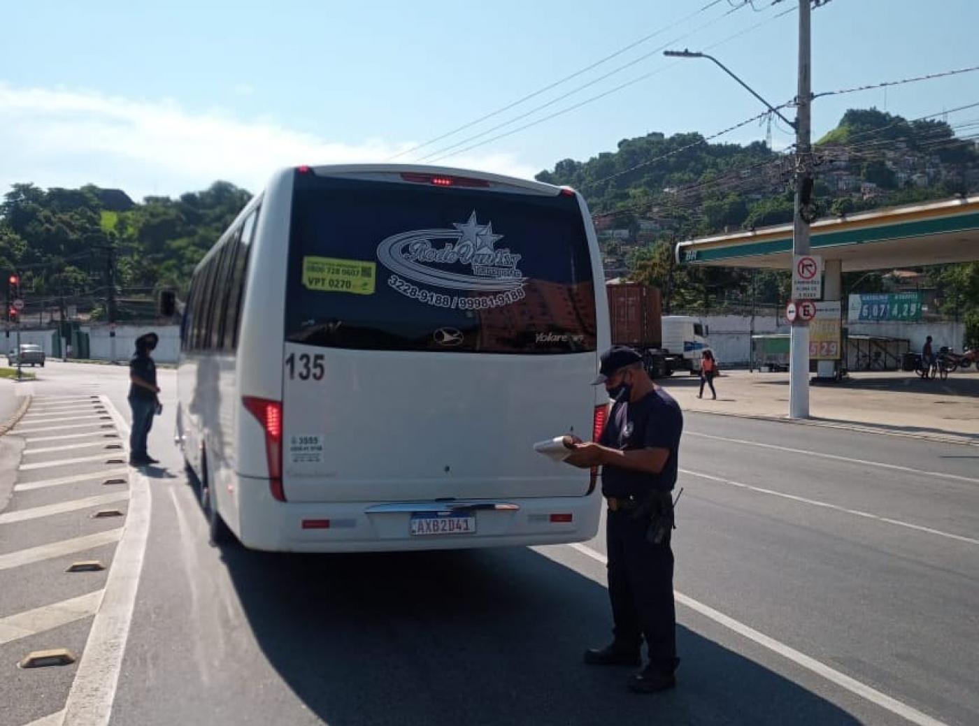 ônibus parado na via sendo abordado por guardas #paratodosverem