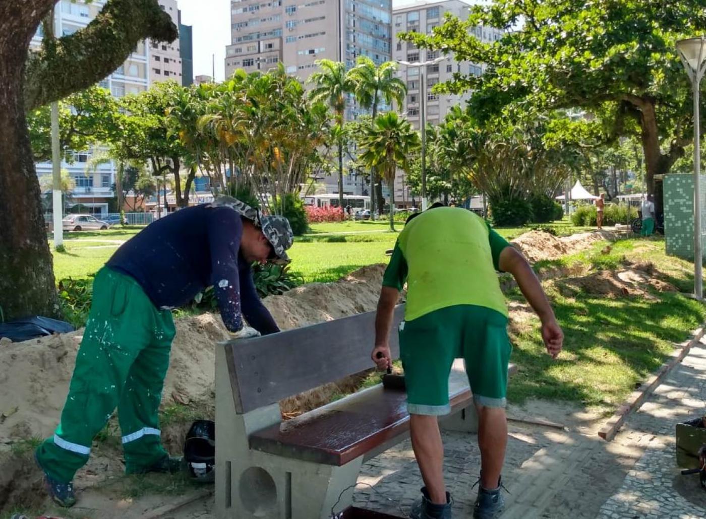 dois trabalhadores realizando serviço no banco da praia #paratodosverem