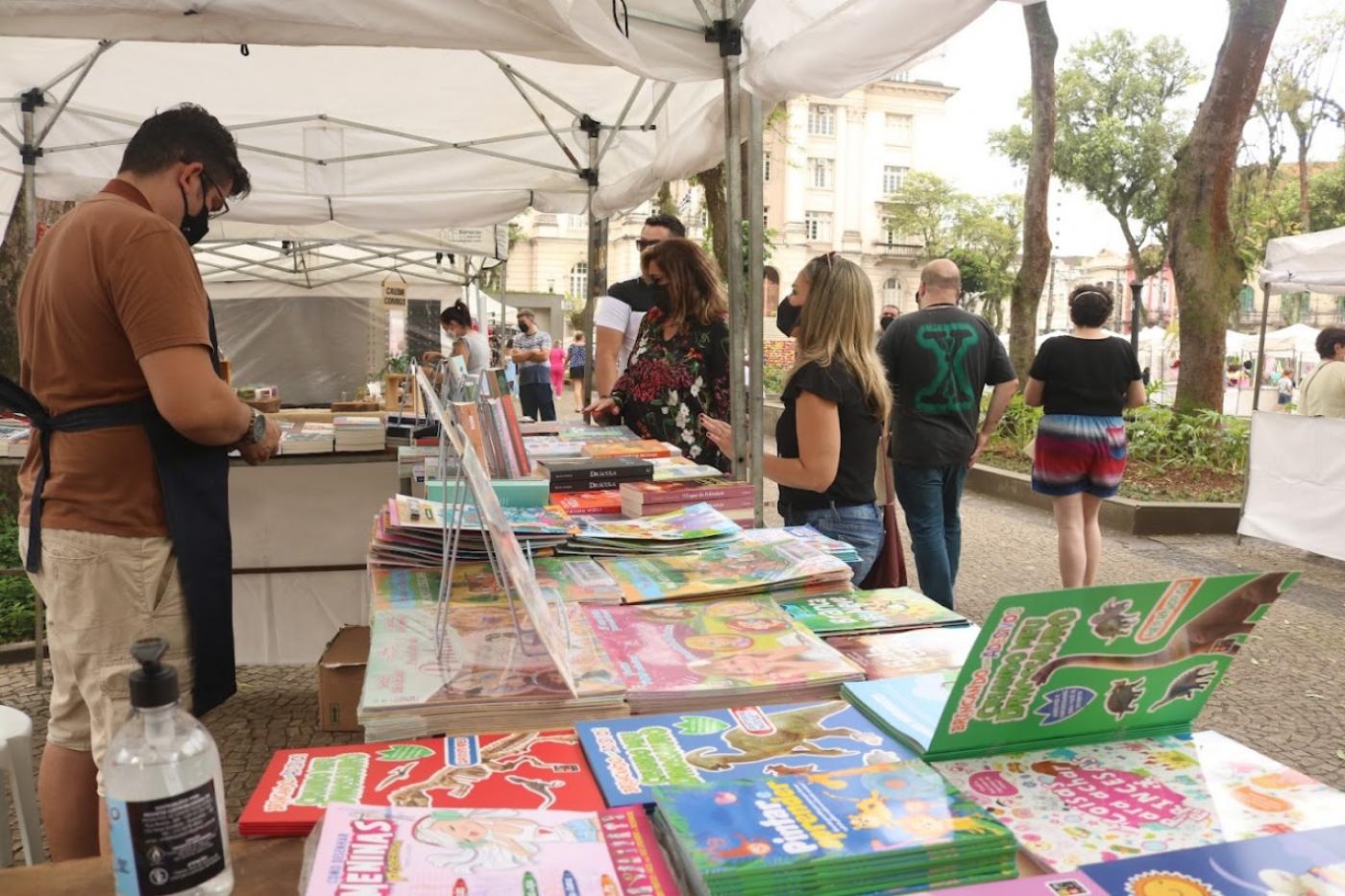 pessoa em uma tenda com livros infantis