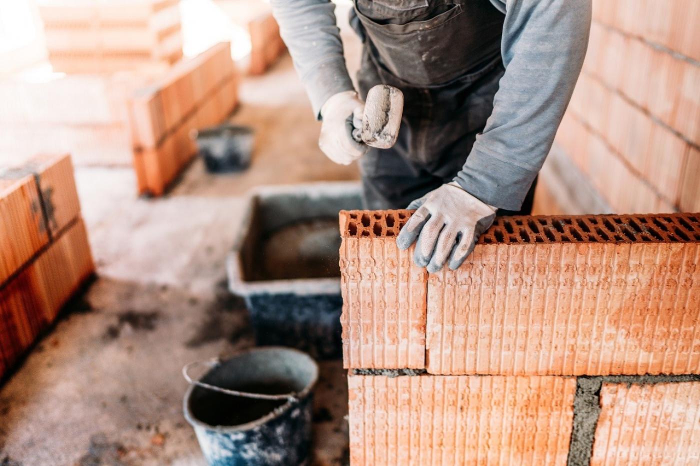 mãos mexendo em tijolos em obra #paratodosverem