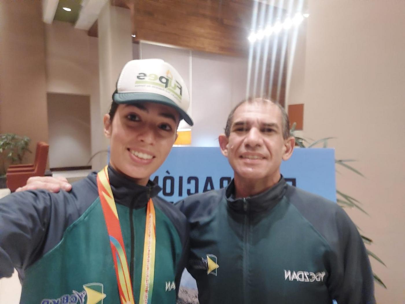 atleta com medalha e professor ao lado #paratodosverem