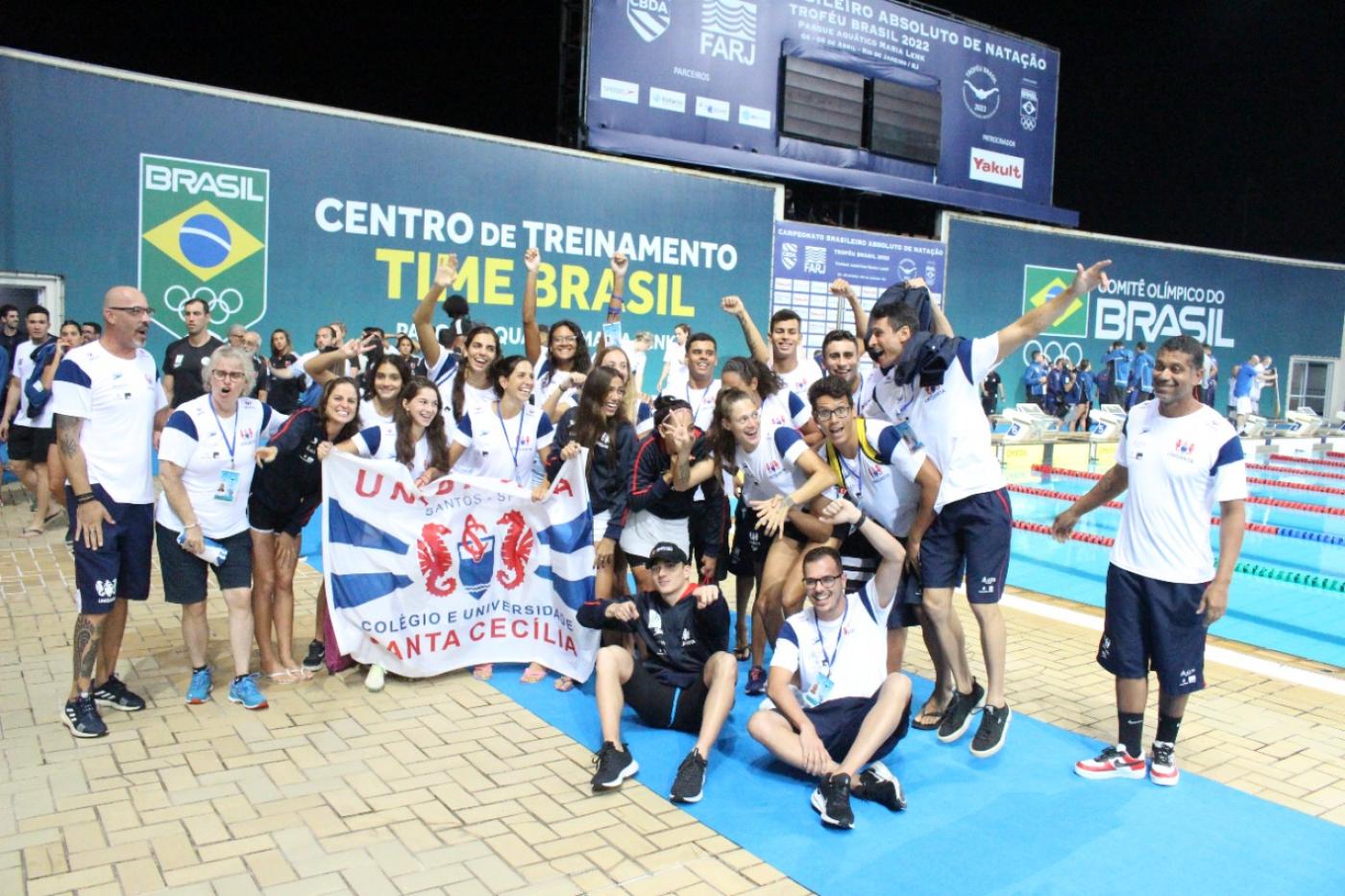 diversos atletas posam para foto com bandeira no parque aquático #paratodosverem