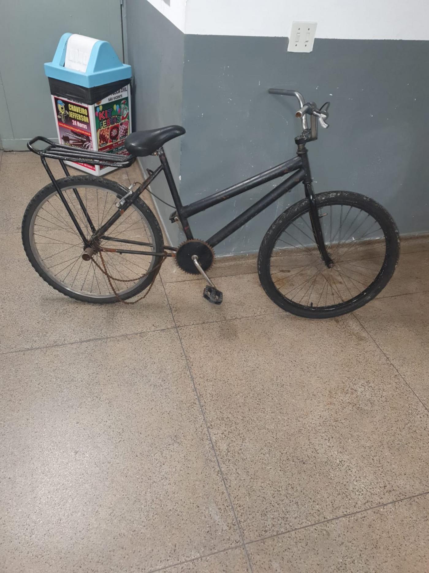 bicicleta na cor preta apoiada a um balcão #paratodosverem