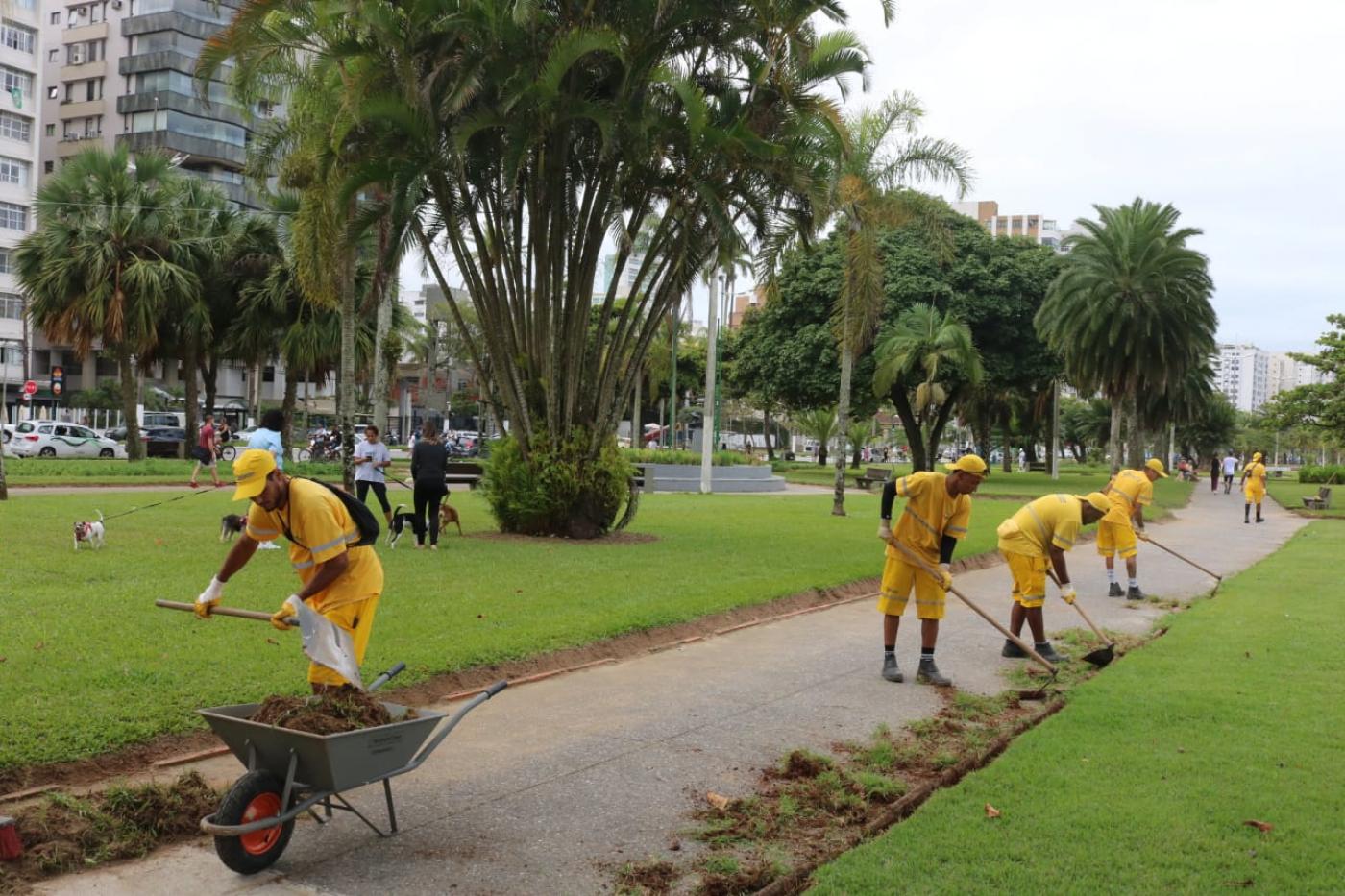 trabalhos realizam serviço na grama do jardim da orla #paratodosverem