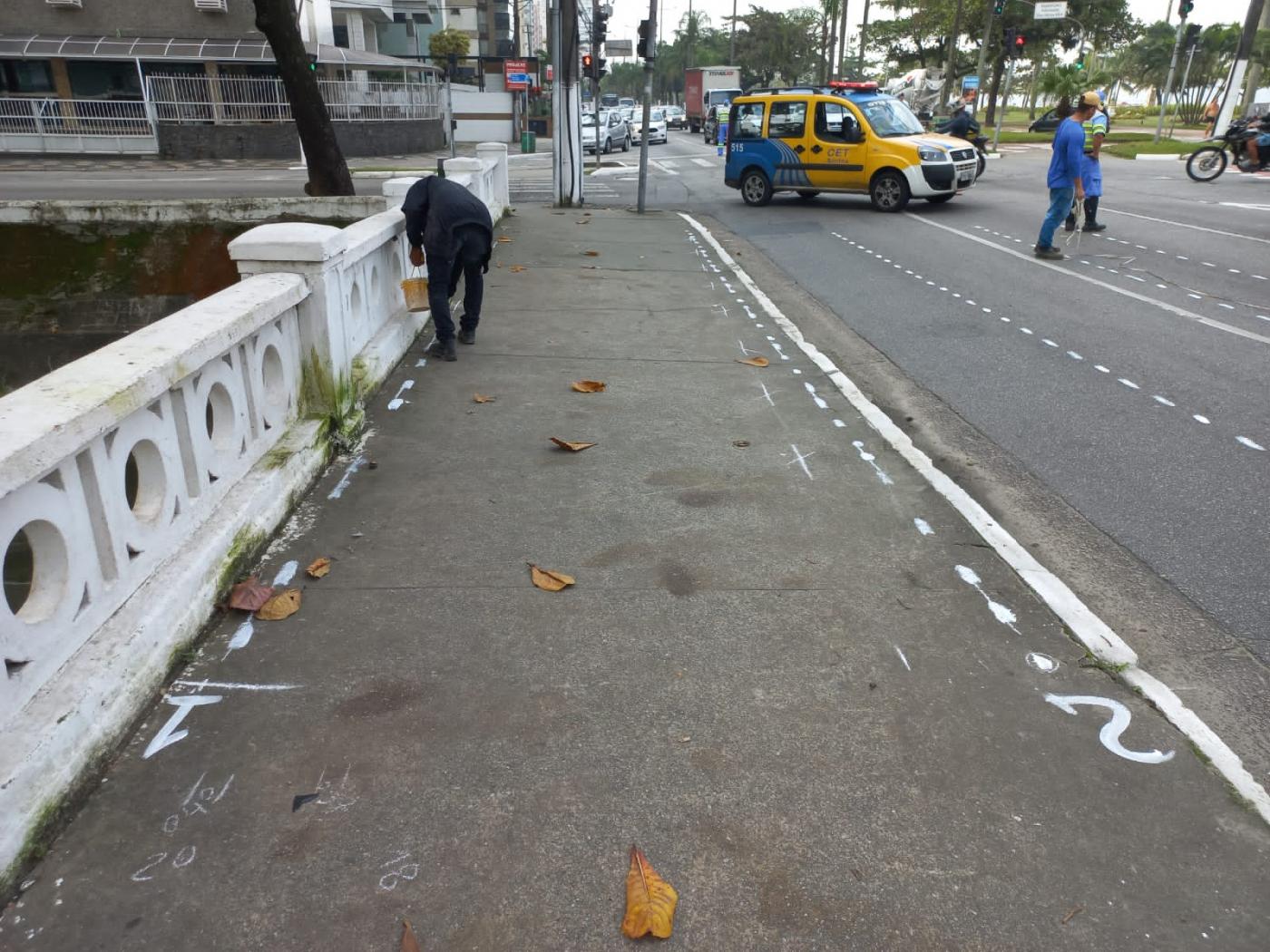 homem faz demarcações em calçada ao lado do canal com pista interditada pela cet #paratodosverem