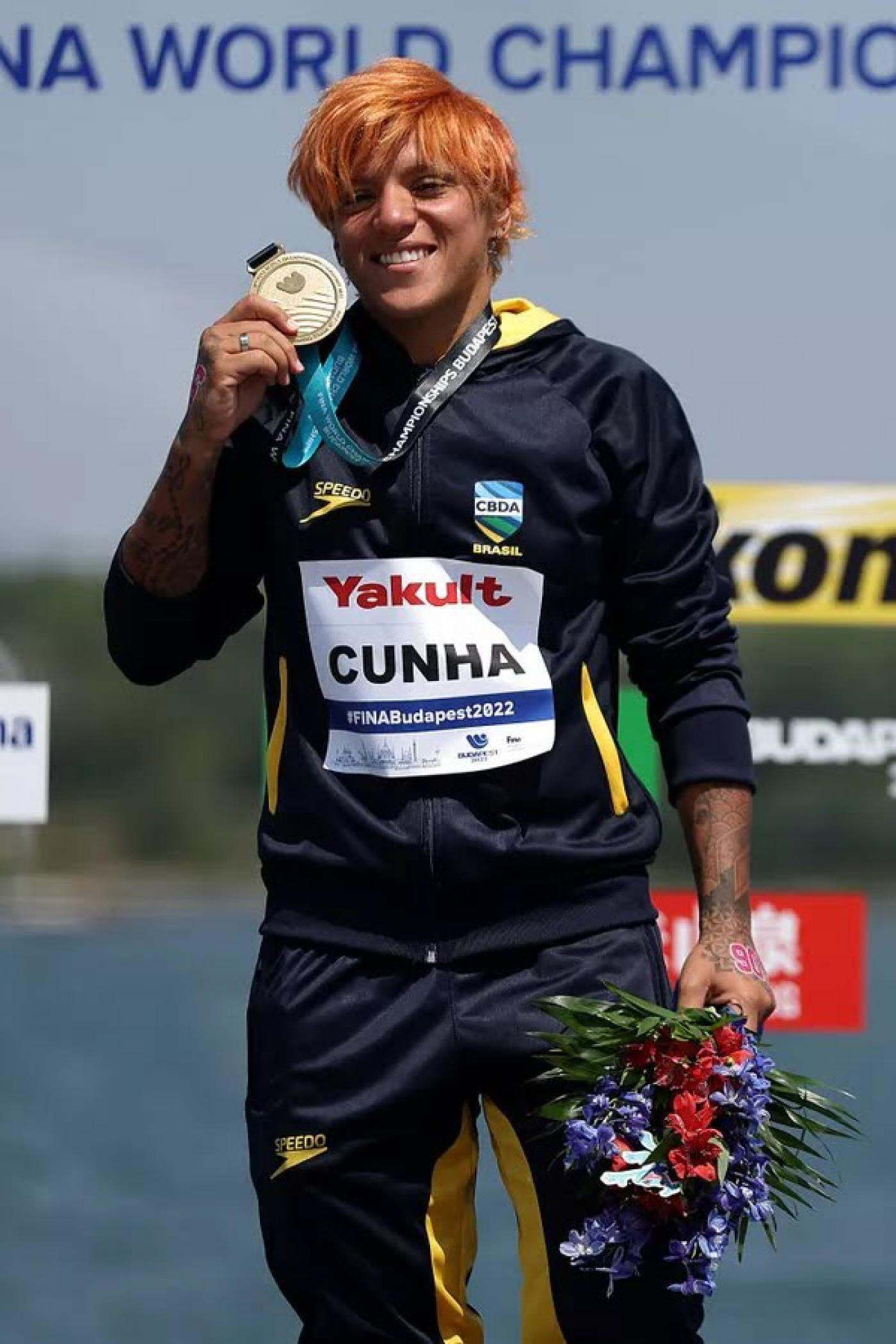 atleta segurando a medalha #paratodosverem