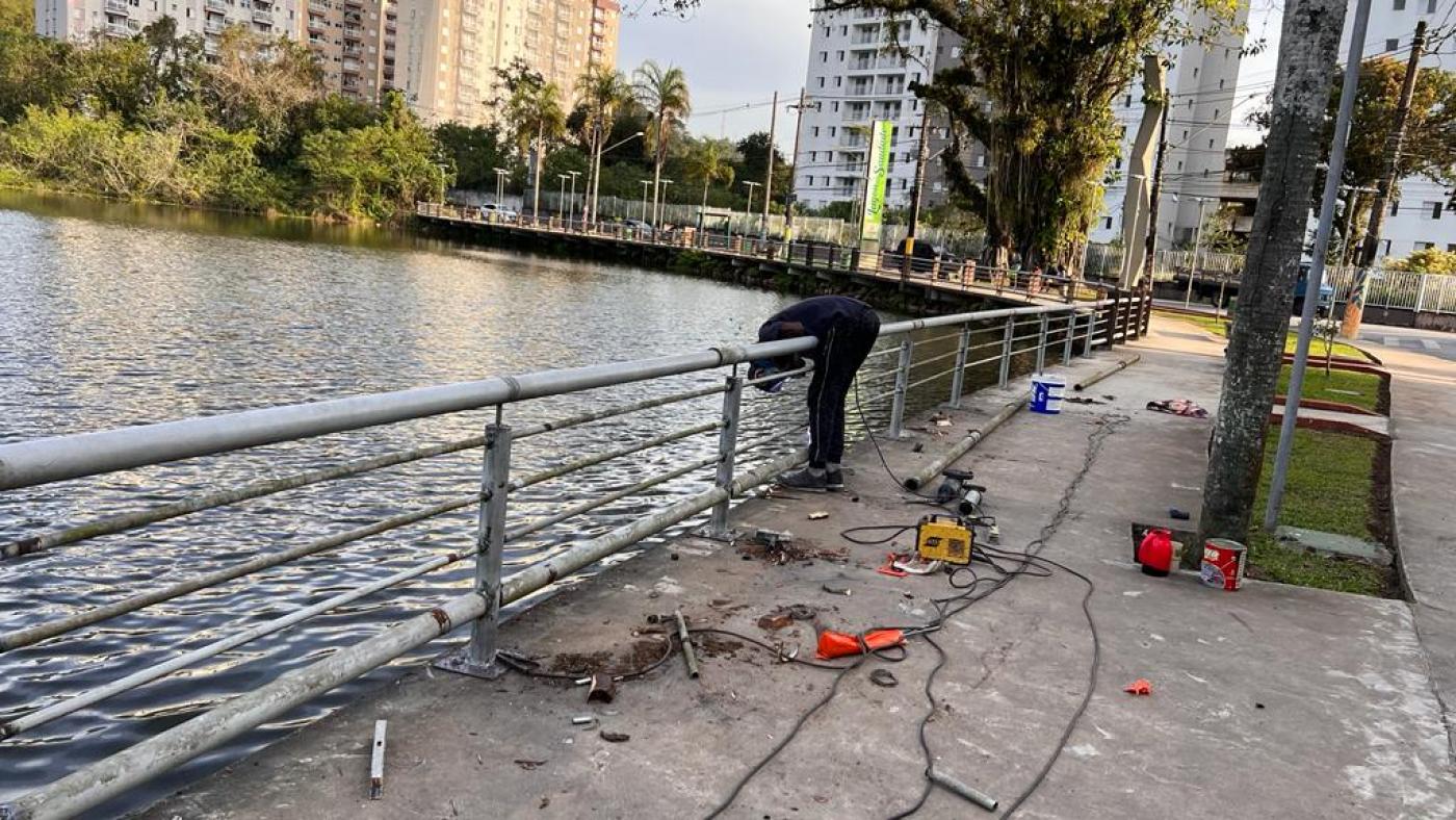 homen trabalhando em guarda-copo que contorna lagoa #paratodosverem