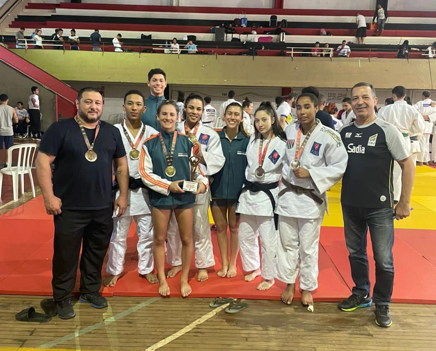 judocas com medalha em cima do tatame #paratodosverem