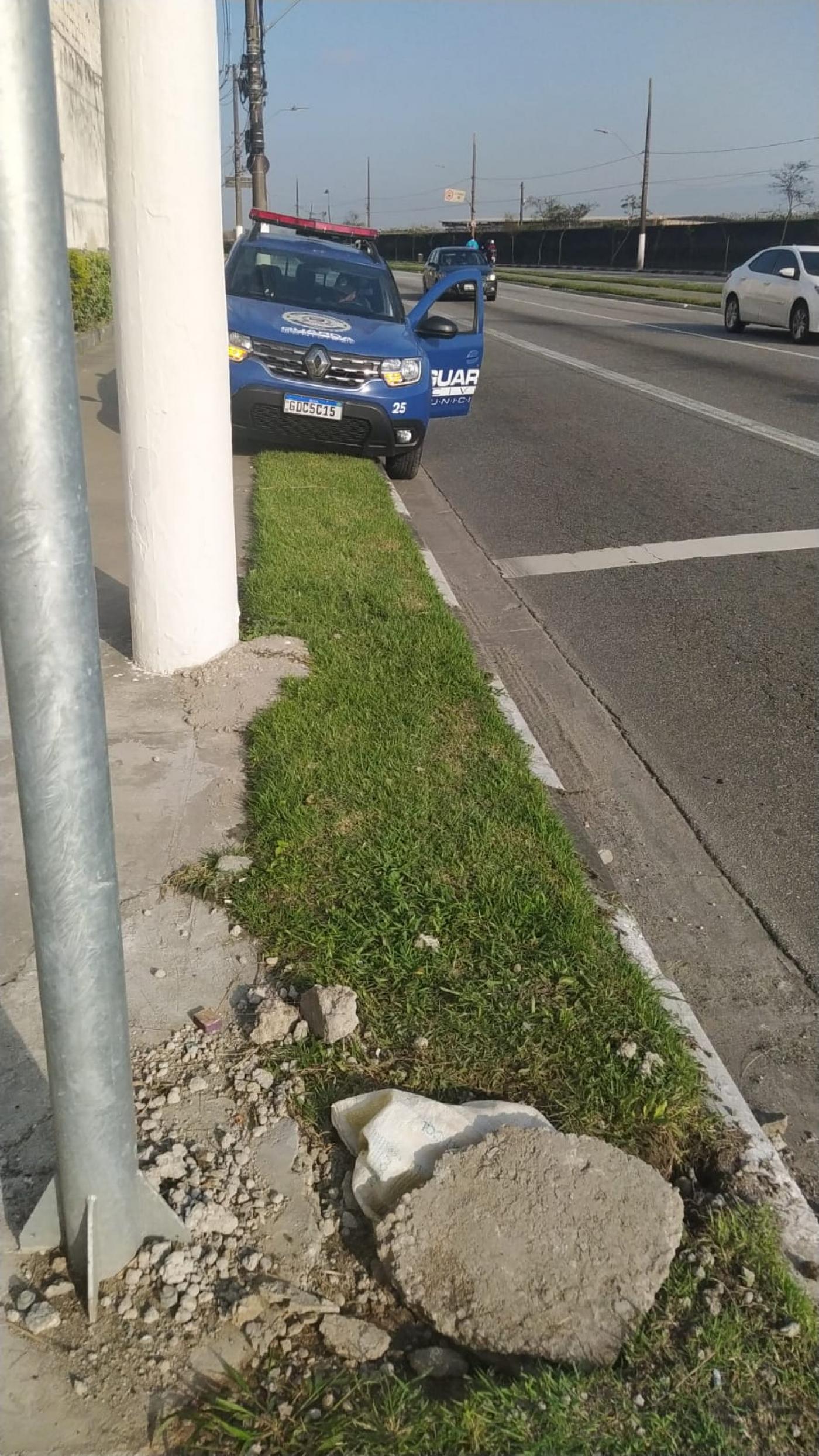 viatura da guarda municipal ao fundo e buraco aberto no canteiro de avenida. #paratodosverem