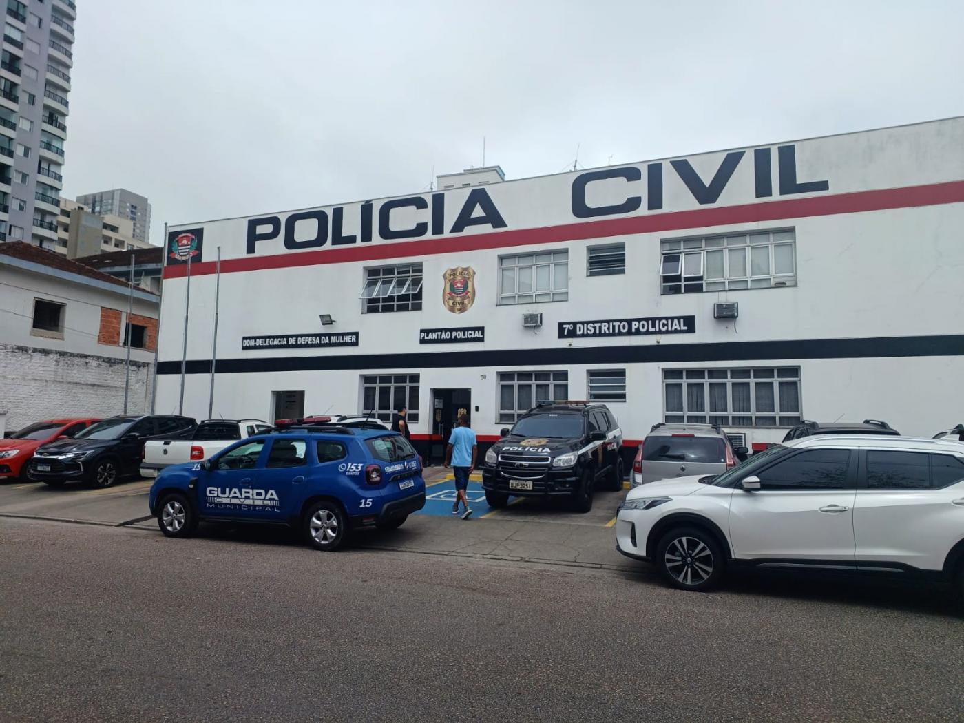 fachada do 7º DP com carros e uma viatura da guarda à frente. #paratodosverem 