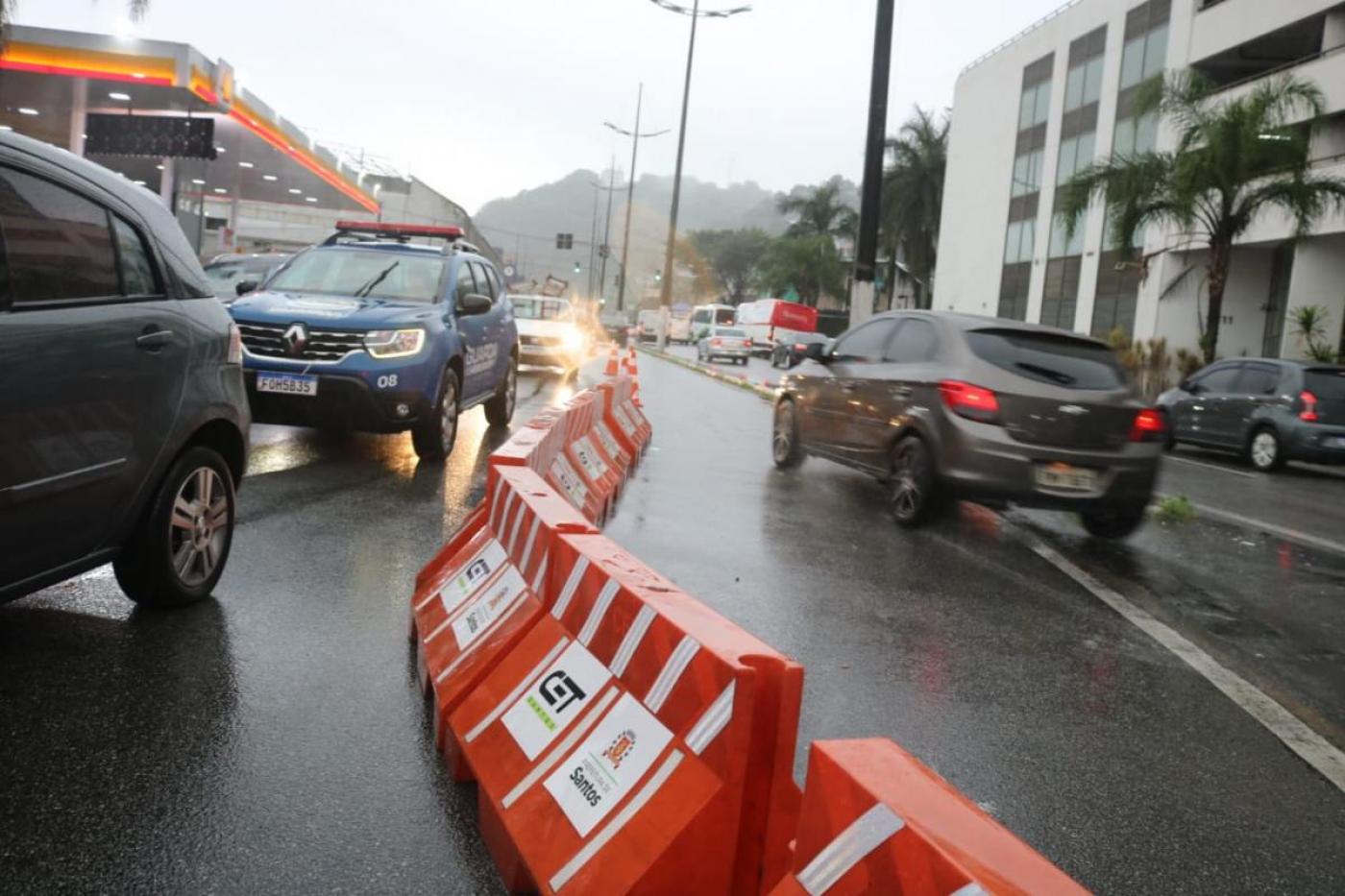 carros circulando por rua separados por defensas de plástico. #paratodosverem