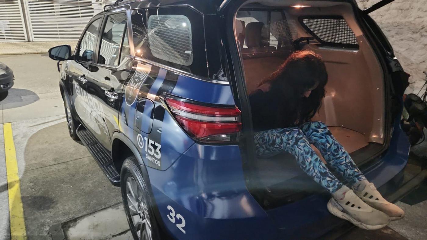 mulher está saindo do porta-malas de viatura da guarda municipal. Não se vê o rosto. #paratodosverem 