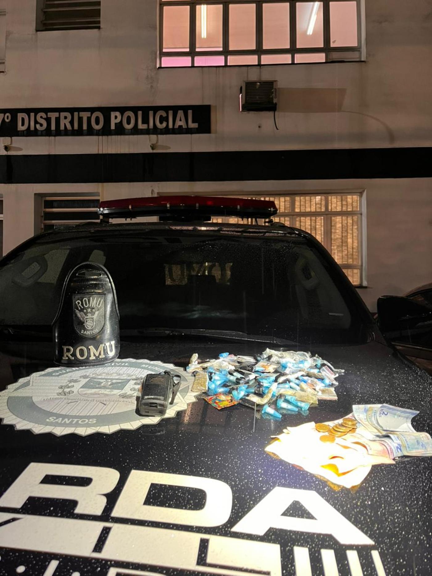 drogas, rádio e dinheiro sobre capô de viatura da guarda municipal. #paratodosverem 