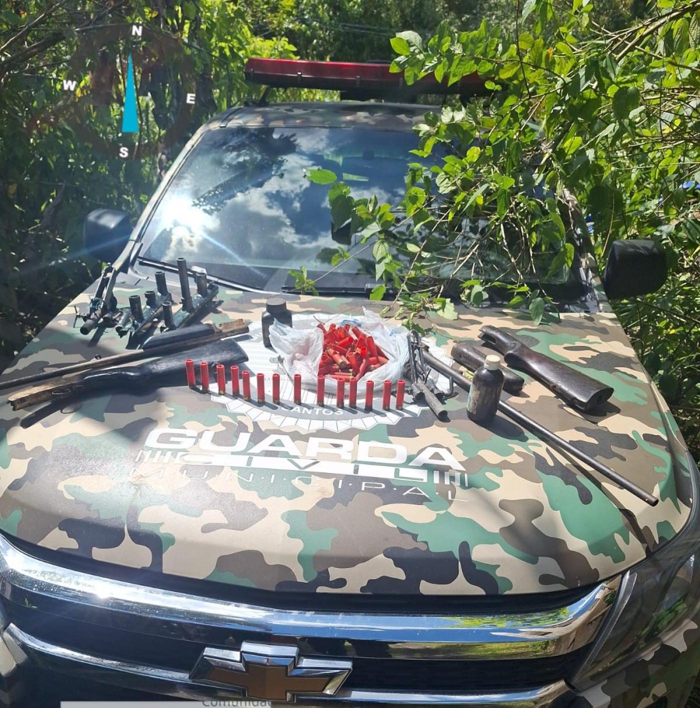 armas estão dispostas sobre capô de viatura da guarda civil municipal ambiental. #paratodosverem 