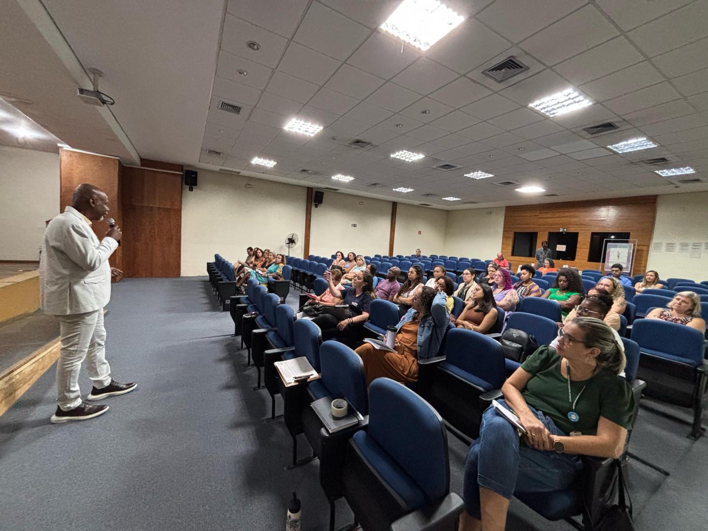 palestrante fala em pé ao auditório #paratodosverem 