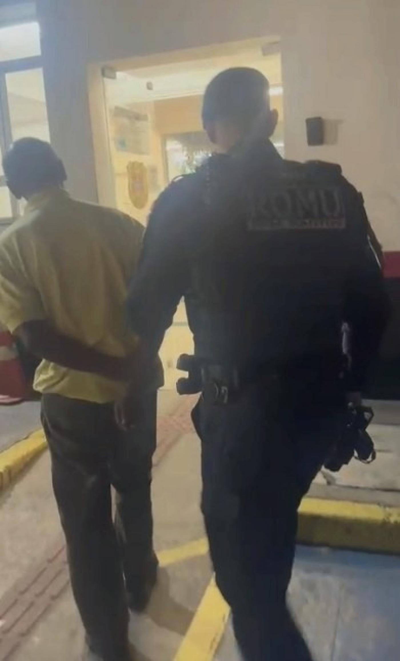 guarda conduz homem de costas para a foto. #paratodosverem