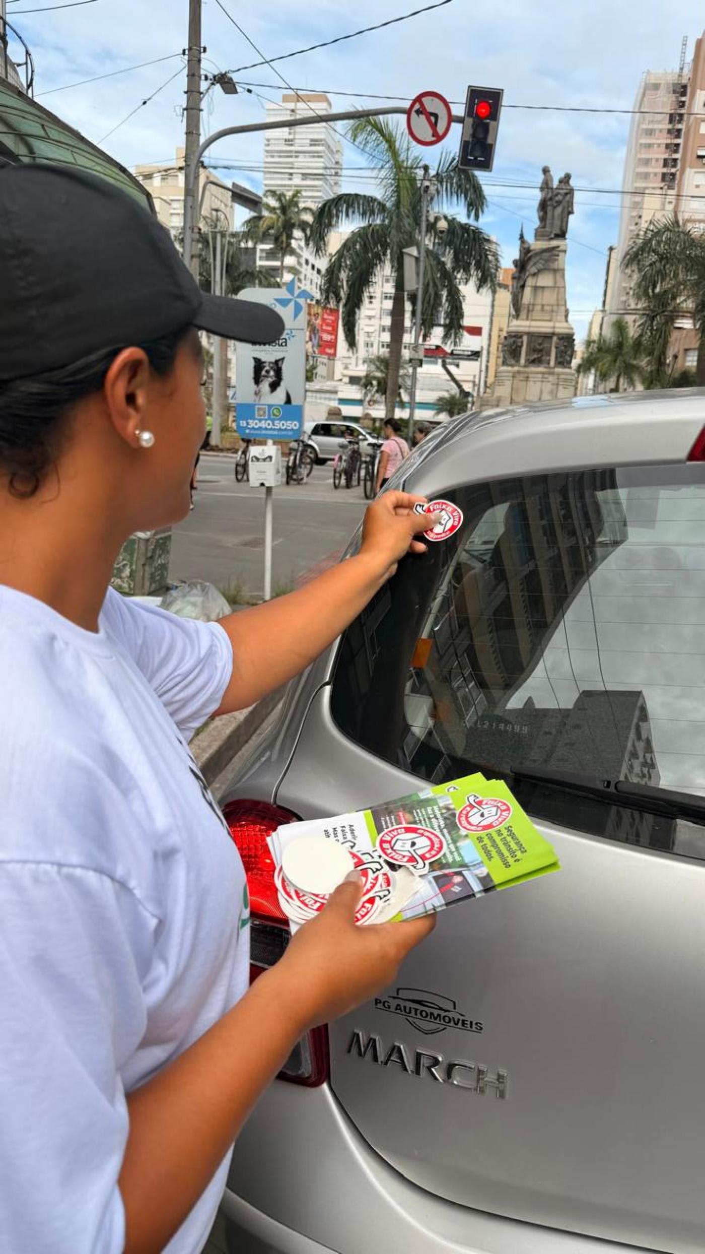 mulher coloca selo em carro #paratodosverem 