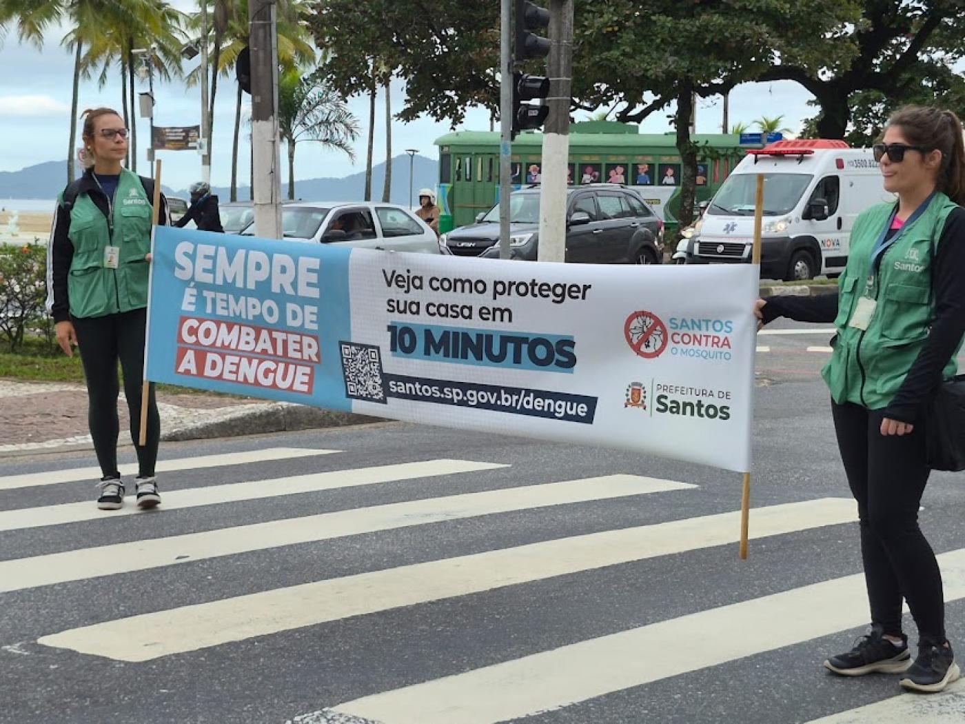 agentes seguram faixa com dizeres em semáforo. #paratodosverem