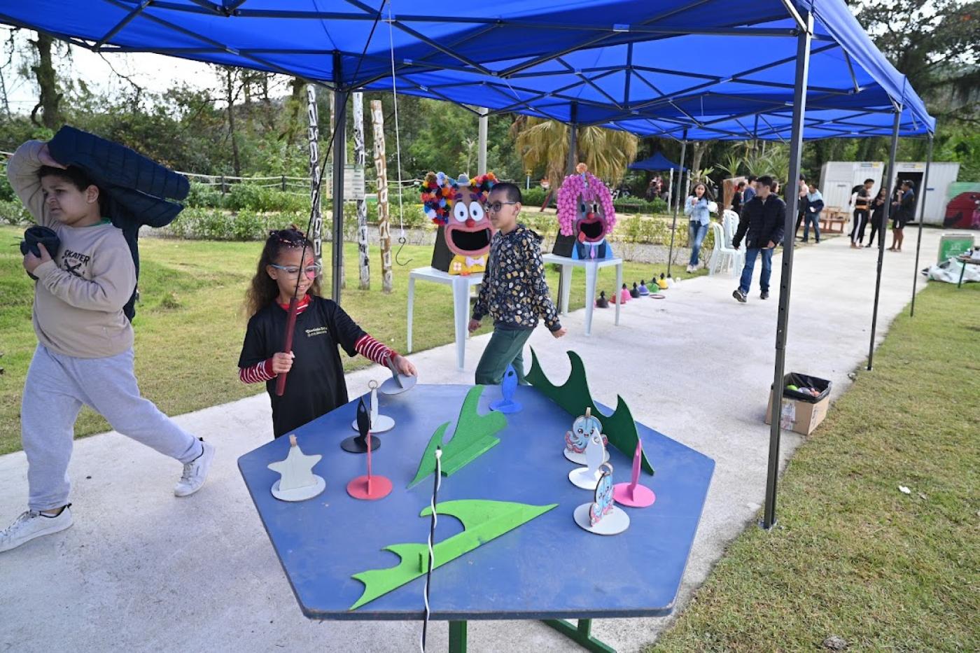 criança brincando em pescaria #paratodosverem