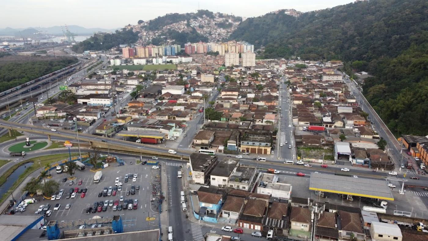 vista geral aérea de bairros com morro ao fundo. #paratodosverem