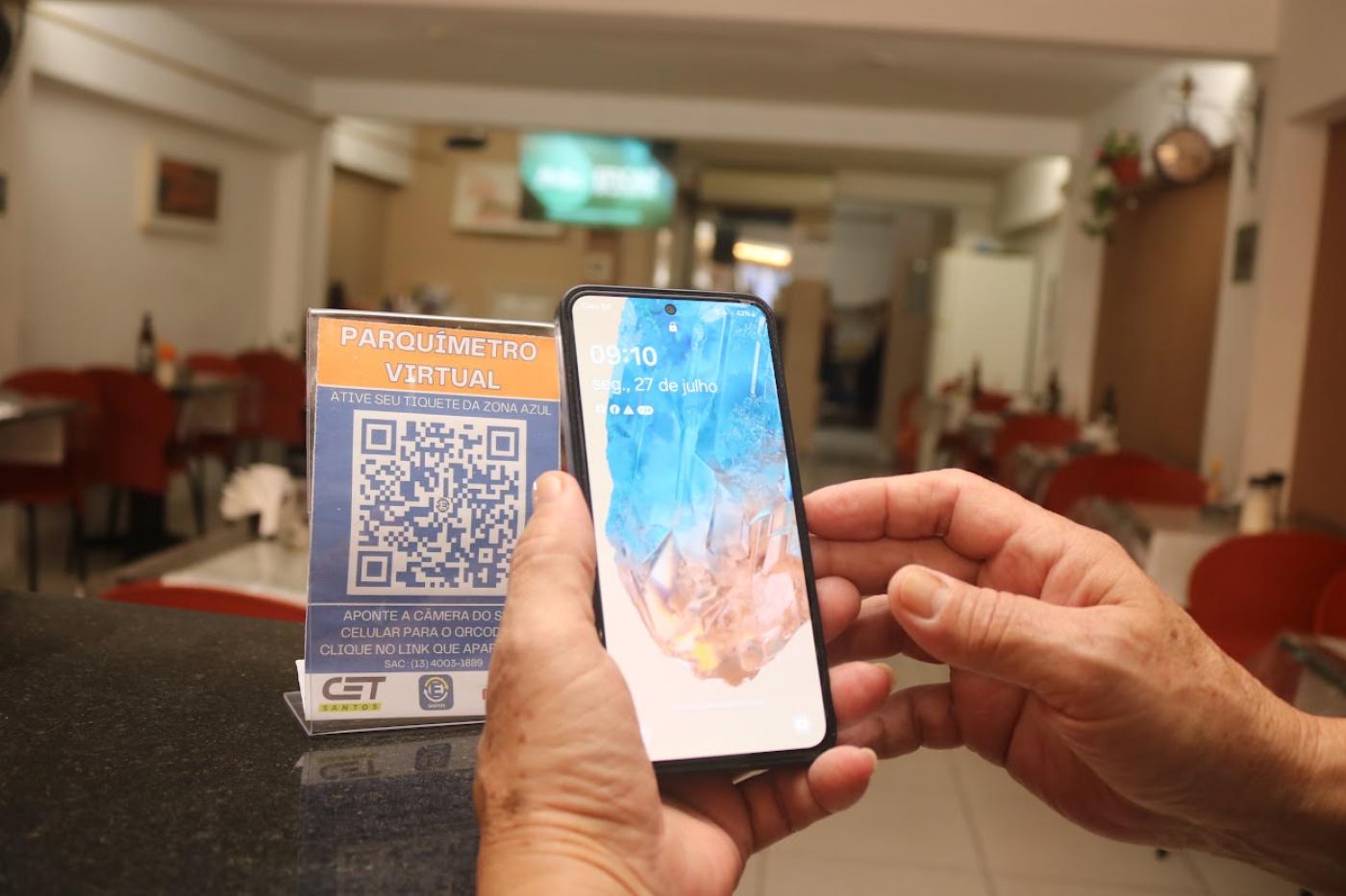 mão aproxima celular de QR code #paratodosverem 