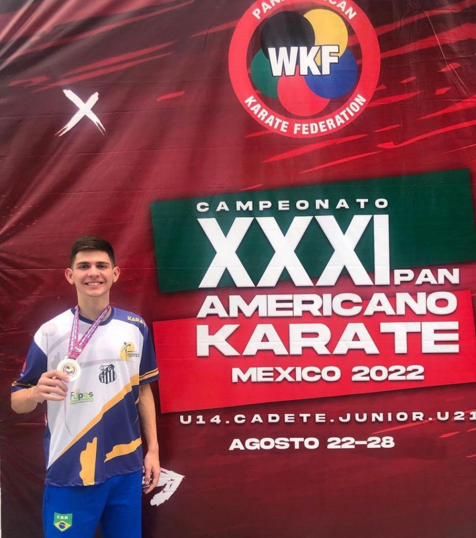 Matheus Bortolomasi posa para foto segurando medalha que está pendurada no pescoço. #paratodosverem