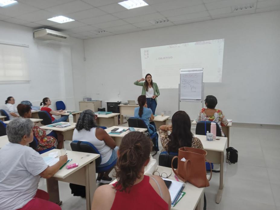 mulheres estão sentadas assistindo palestra. #paratodosverem