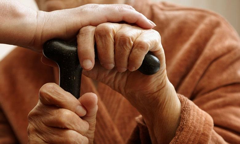pessoa coloca a mão sobre a mão de idoso segurando bengala #paratodosverem